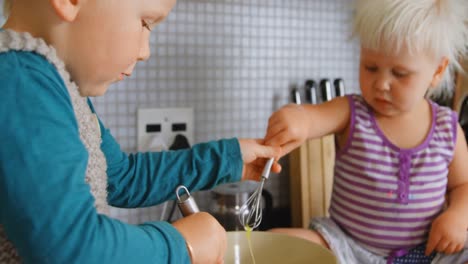 -Siblings-stirring-eggs-with-whisker-4k