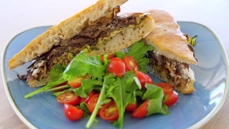 delicious ciabatta sandwich bread, grilled eggplants, zucchini and cherry tomatoes on plate