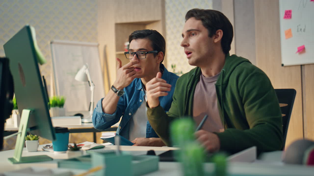 캐비에서 컴퓨터를 작업하는 심각한 남자. 프로젝트를 함께 논의하는 동료