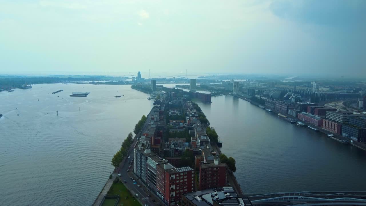 Flying Above KNSM Island On IJ River At Dusk In Amsterdam, Netherlands. aerial shot