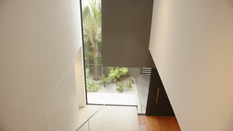 modern home interior with large window overlooking garden and wooden flooring
