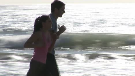 two people jogging along a beach