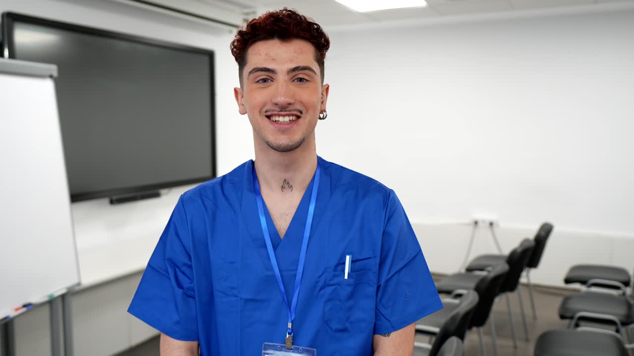 Joven estudiante de enfermería de pie y sonriendo en un aula.