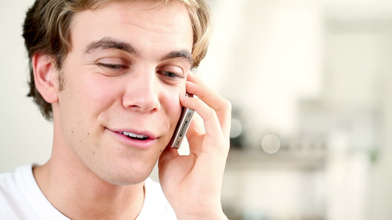 매력적인 젊은 남자가  ⁇ 드폰으로 채팅하고 있습니다.