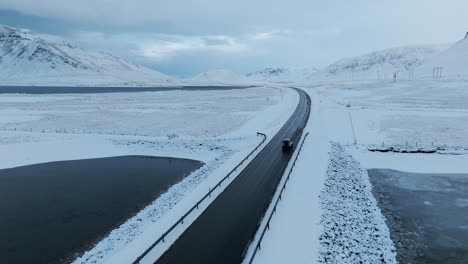 kolgrafarfjörður bridge aerial shot tracking white jeep as it crosses snowy bridge iceland daytime