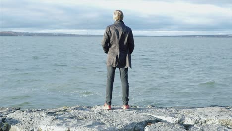 man standing on the shore of a lake