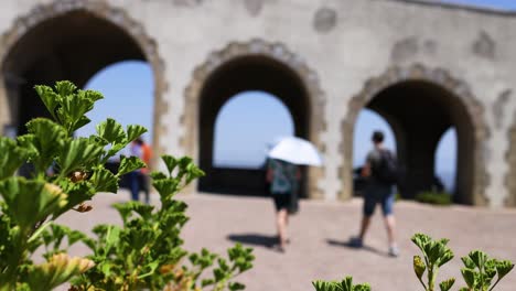 people walking under arches in naples, italy