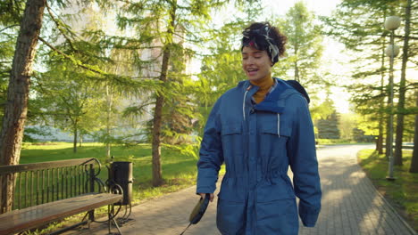 woman walking her dog in a sunny park