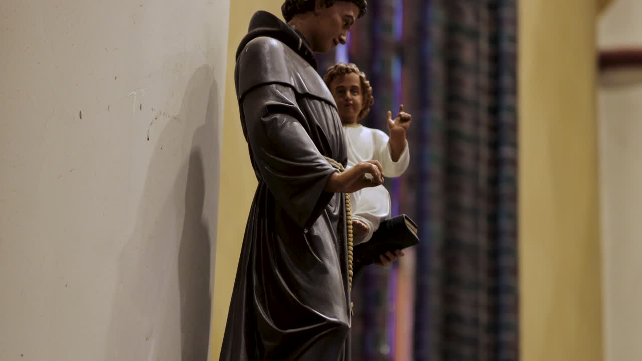 Una statua antica di un santo che tiene in braccio un bambino in una chiesa in Europa Centrale, ripresa in risoluzione 4K