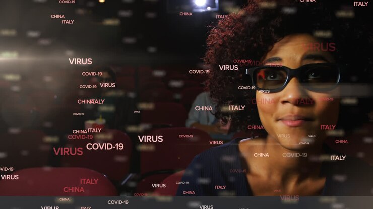 Covid-19 concept texts against group of friends watching movie in theatre