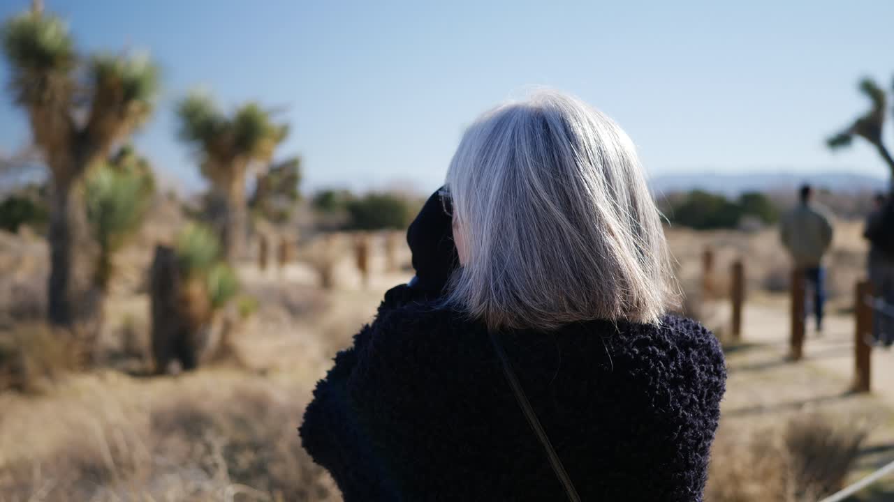 사막의 자연 보호 공원 풍경에서 그녀의 구식 필름 카메라와 렌즈로 사진을 찍는 여자