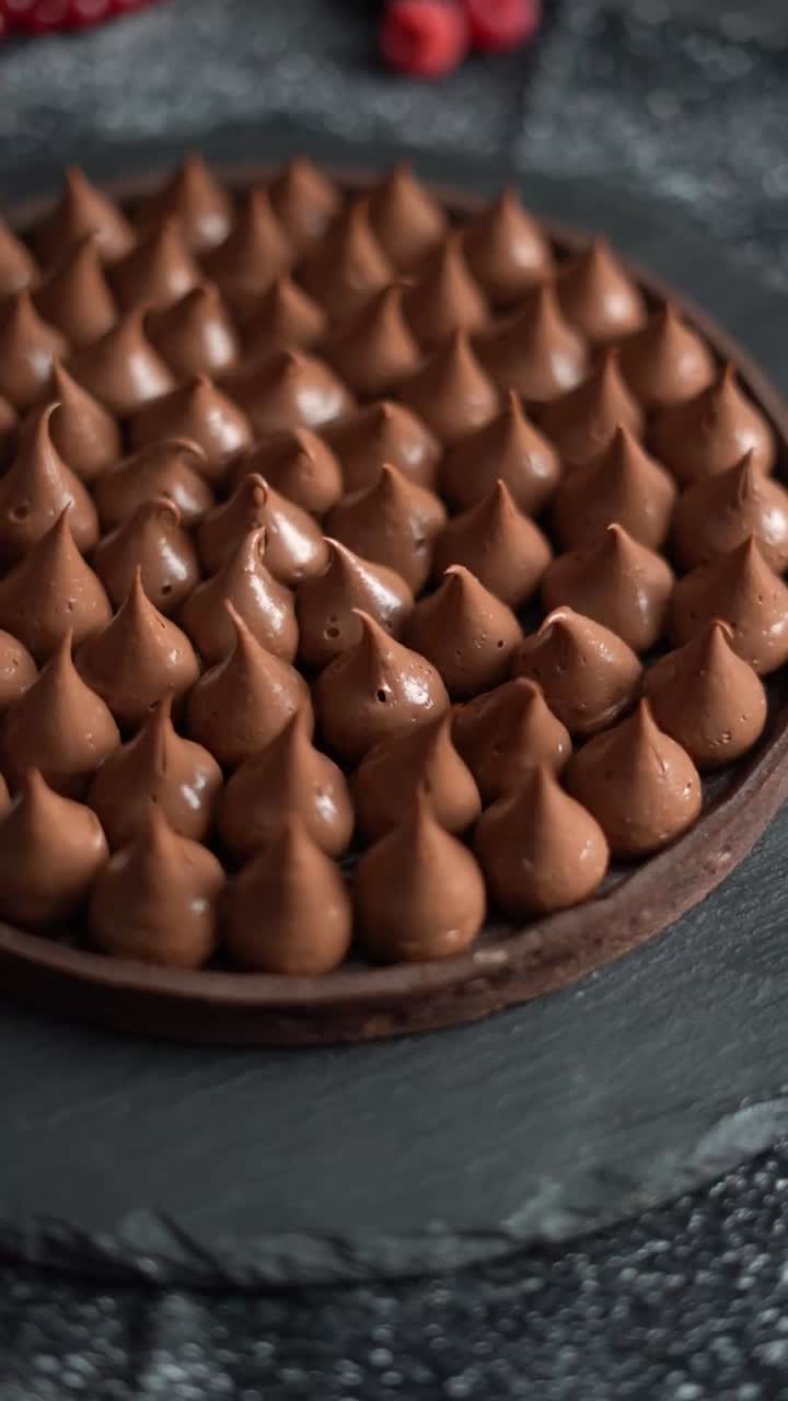 Primo piano di crostatina al cioccolato con panna montata e frutti di bosco freschi