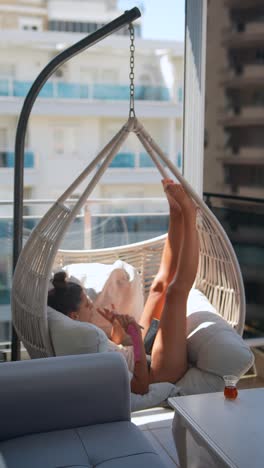 woman relaxing in a hanging chair on a balcony