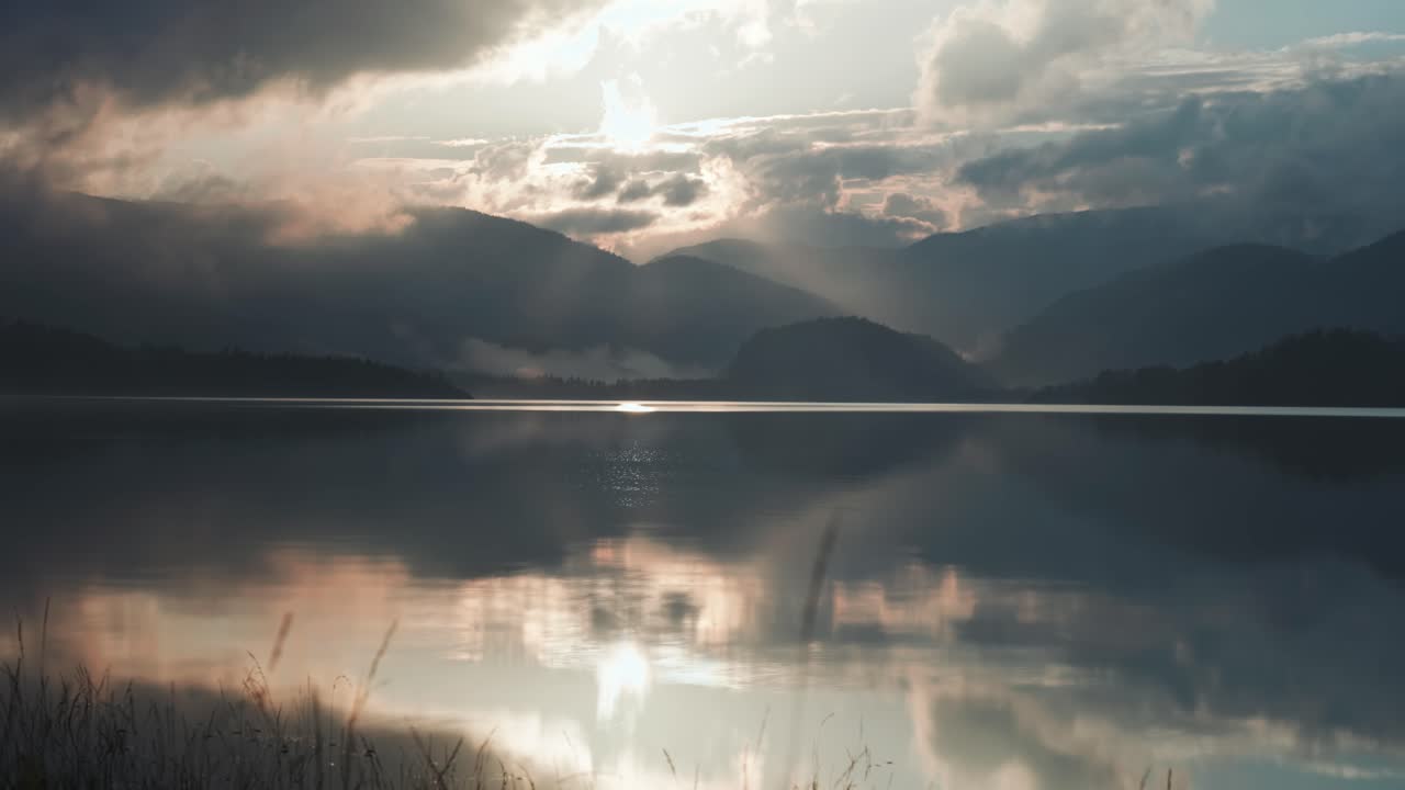 해가 지는 하늘의 활기찬 색채는 호수의 조용한 물에 반사됩니다.
