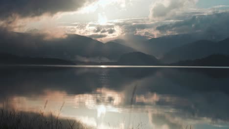 los vibrantes tonos del cielo al atardecer se reflejan en las aguas tranquilas del lago.