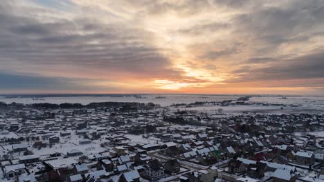 epic puesta de sol de fuego de rayos de luz amarilla corre a través del cielo nublado sobre el vecindario cubierto de nieve