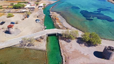 aerial view of the old windmills and stone bridge over the canal at elounda, crete