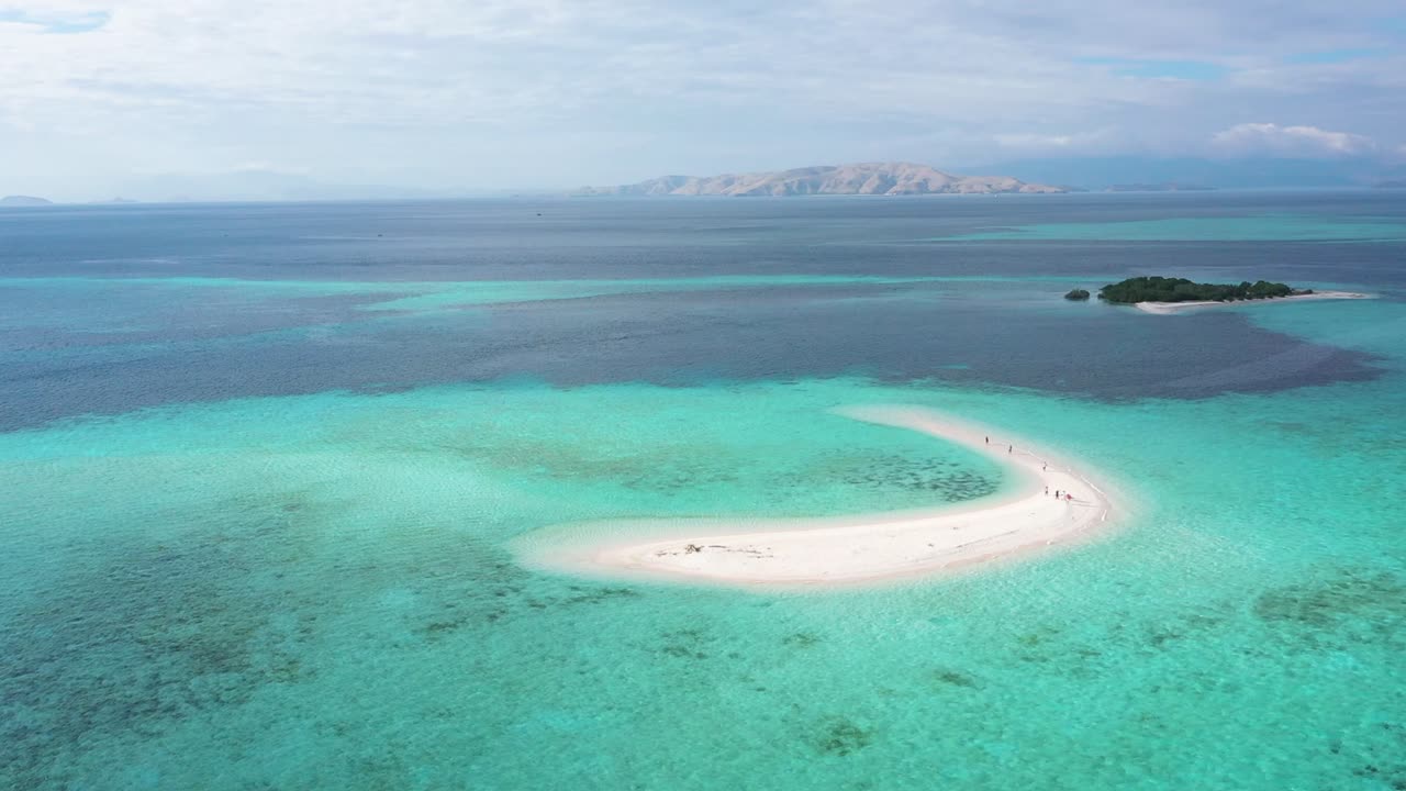 excelente toma aérea de turistas y pequeñas lanchas motoras cerca de la isla de arena en el parque nacional de komodo en indonesia