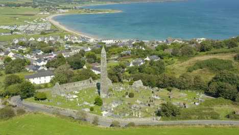 beautiful aerial view,4k, pan right, ardmore round tower built in the 12th-century and the ruins of a cathedral dating from the 12th and 13th centuries