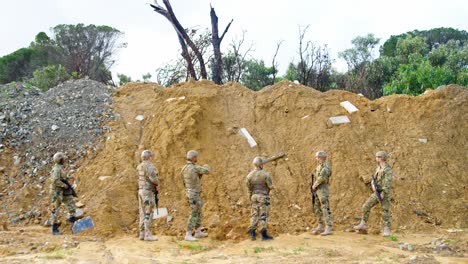 Vista-Trasera-De-Soldados-Militares-De-Raza-Mixta-Entrenando-Con-Rifles-En-Campos-Durante-El-Entrenamiento-Militar-4k