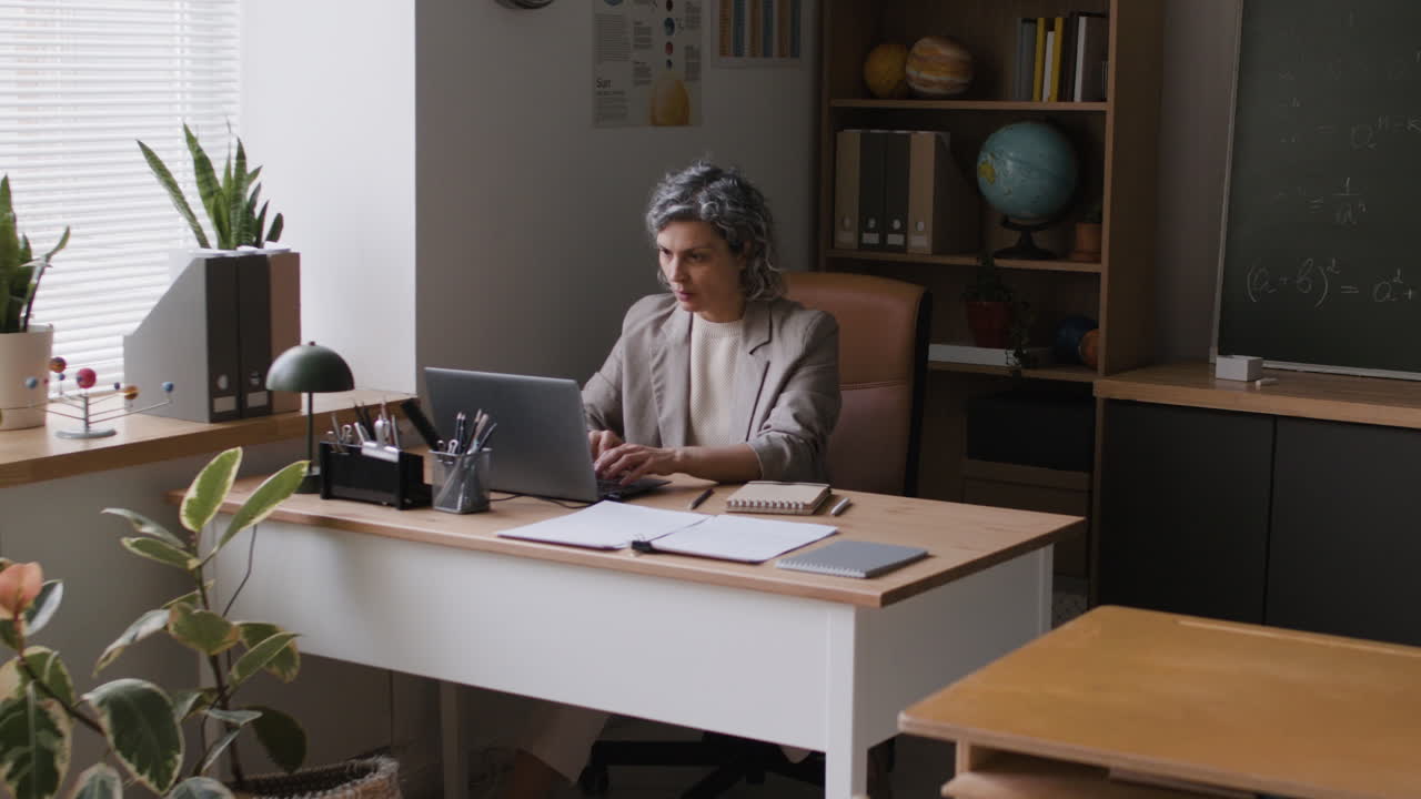 Teacher working on laptop in a classroom