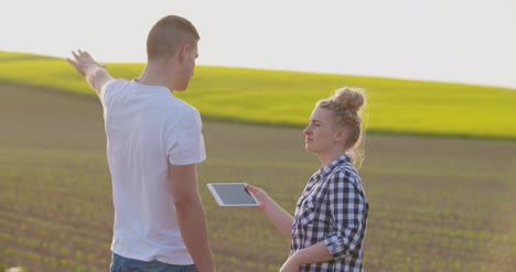 Farmers-Discussing-While-Using-Tablet-Computer-At-Farm-7