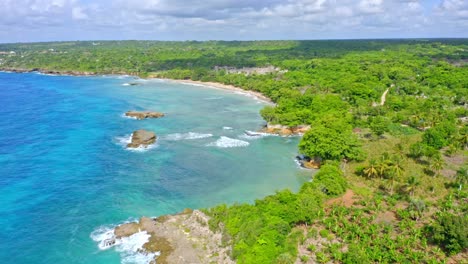 idyllic aerial view above picturesque caribbean coastline, lush tropical vegetation and turquoise blue ocean - gentle zoom out shot