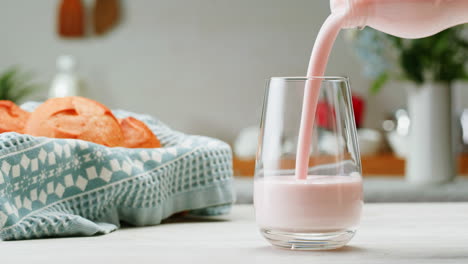 vertiendo yogur de fresa en un vaso