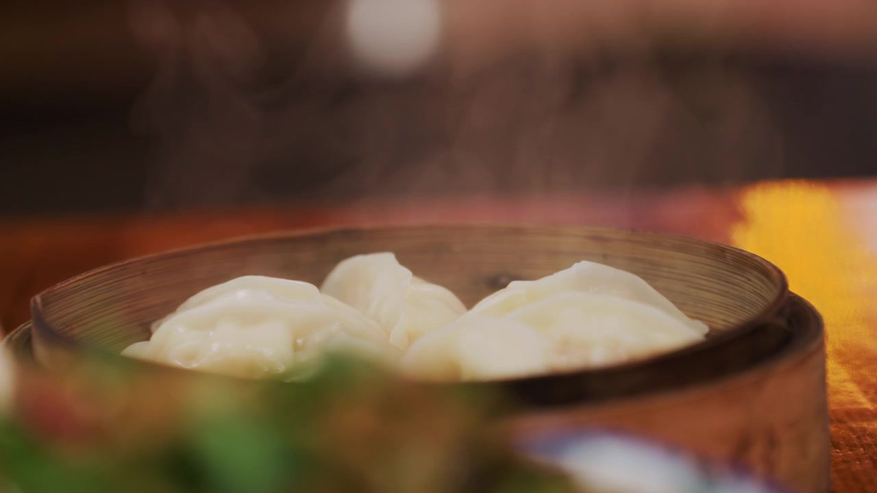 Pangsit Kukus dalam Kukusan Bambu di Malam Hari, Tampilan Dekat Pangsit Kukus Montok yang Mengeluarkan Uap Hangat, Meja Kayu, Hiasan Buram dan Cahaya Bokeh Hangat, Suasana Restoran yang Nyaman dan Aroma yang Menenangkan