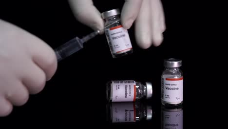 Vaccine-bottles-and-hands-of-nurses-filling-the-syringe-ready-for-Covid-19-vaccination