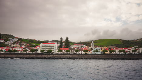 Small-local-town-with-orange-rooftops-located-on-the-rocky-coastline-of-the-Azores-Islands,-Atlantic-ocean,-Portugal