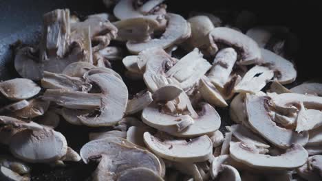 sliced mushrooms cooking in hot skillet