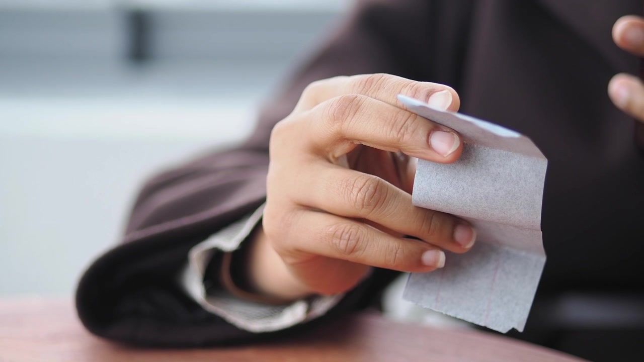 Close-up of a hand holding and reviewing a paper receipt