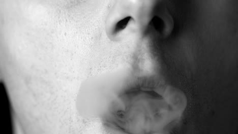 Man-blowing-smoke-rings-in-black-and-white