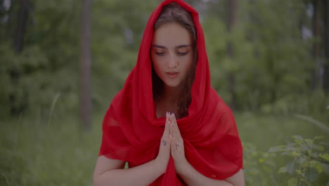 una mujer inocente con un vestido rojo orando.