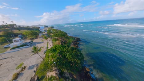 Drone-Volando-Desde-El-Parque-Juan-Lockward-Hacia-El-Parque-La-Puntilla-A-Lo-Largo-Del-Borde-Del-Océano-Atlántico-En-Puerto-Plata,-República-Dominicana