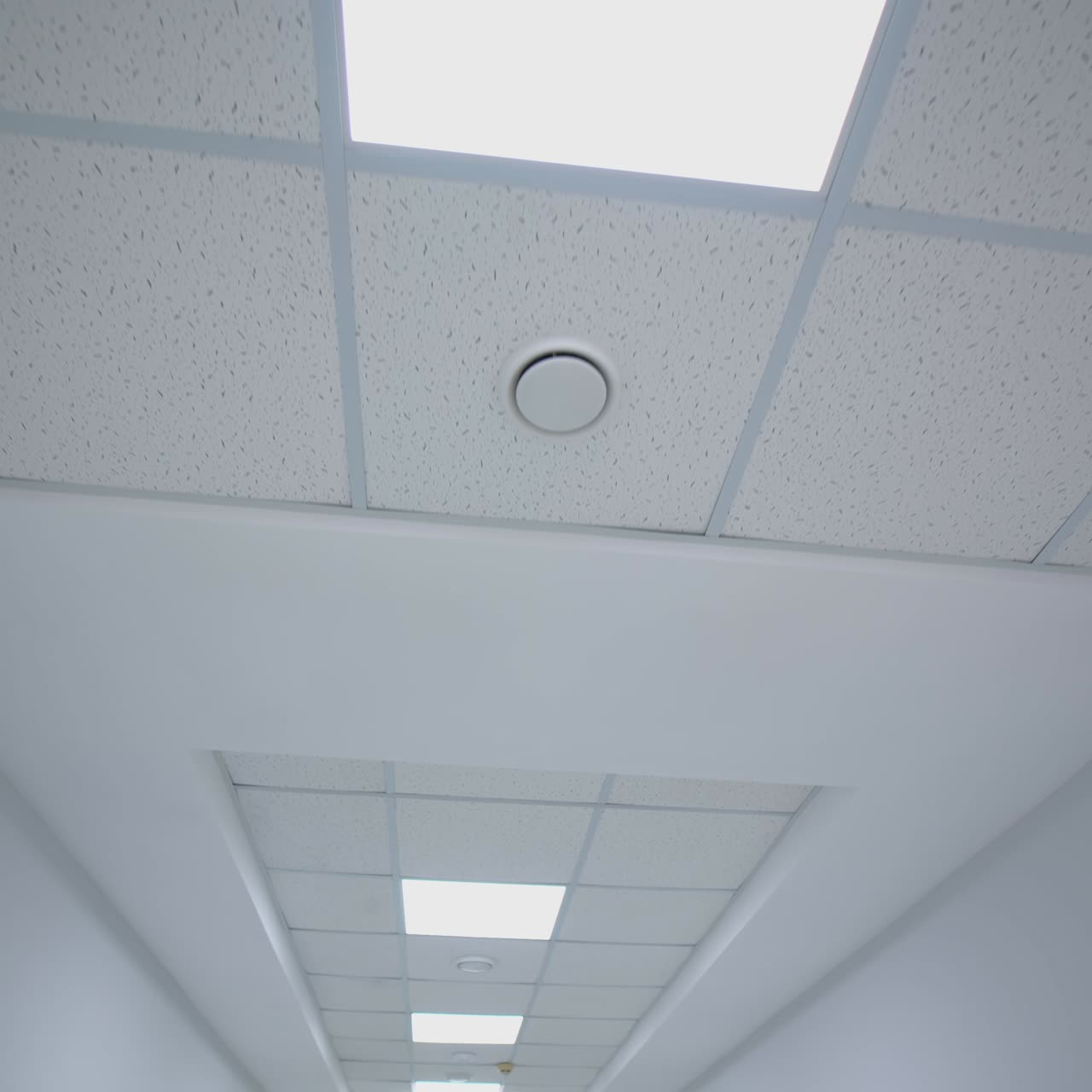 Long corridor with lamps in the hospital. Details of ceiling with lights and framing. Perspective view from a moving stretcher. Motion camera back