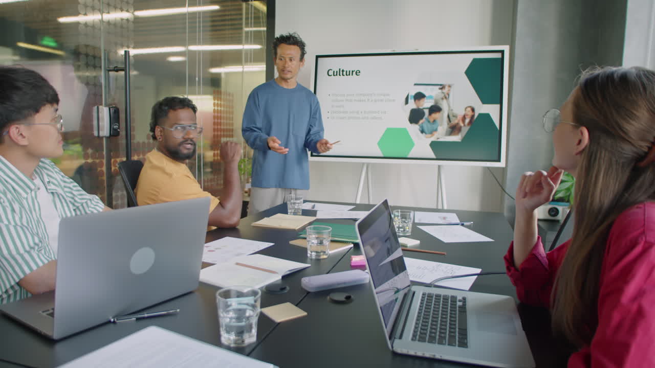 Asian Man Answering Questions at Business Meeting