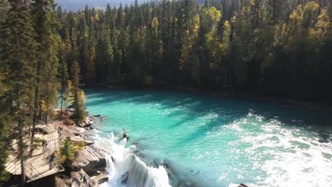 Fliegen-über-Luftzoom-In-Schuss-Von-Nachhut-Fällt-Drohne,-Die-An-Einem-Sonnigen-Tag-Im-Herbst-In-Einer-Waldumgebung-Durch-Bäume-In-Richtung-Der-Wasserfälle-Fliegt