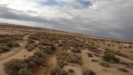 Hochgeschwindigkeitsflug-Entlang-Eines-Trockenen-Flussbetts-In-Der-Mojave-Wüste-Mit-Einer-Ego-Drohne