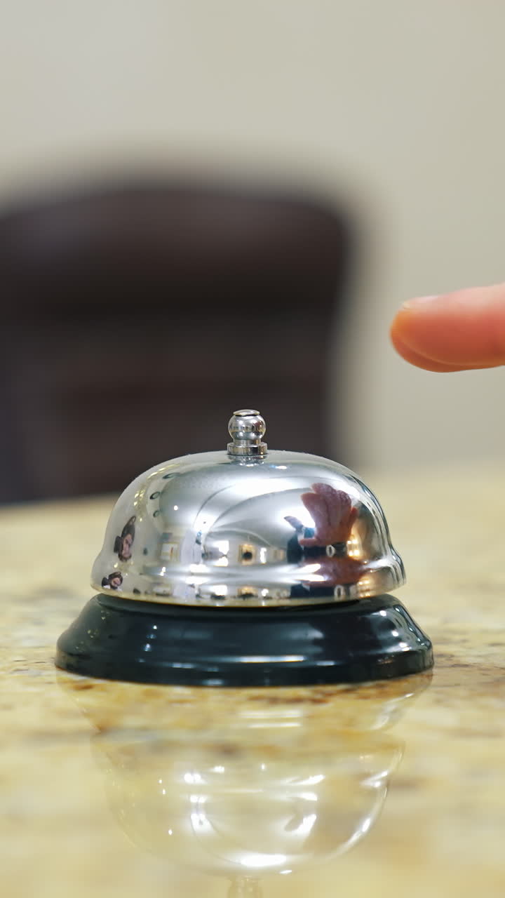 Service bell locating at reception. Customer ringing hotel reception service bell. Vertical video