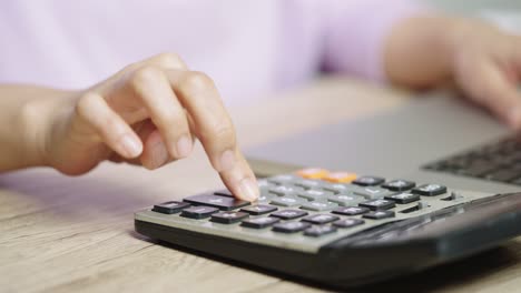 mujer contable de mano usando calculadora para impuestos y presupuesto