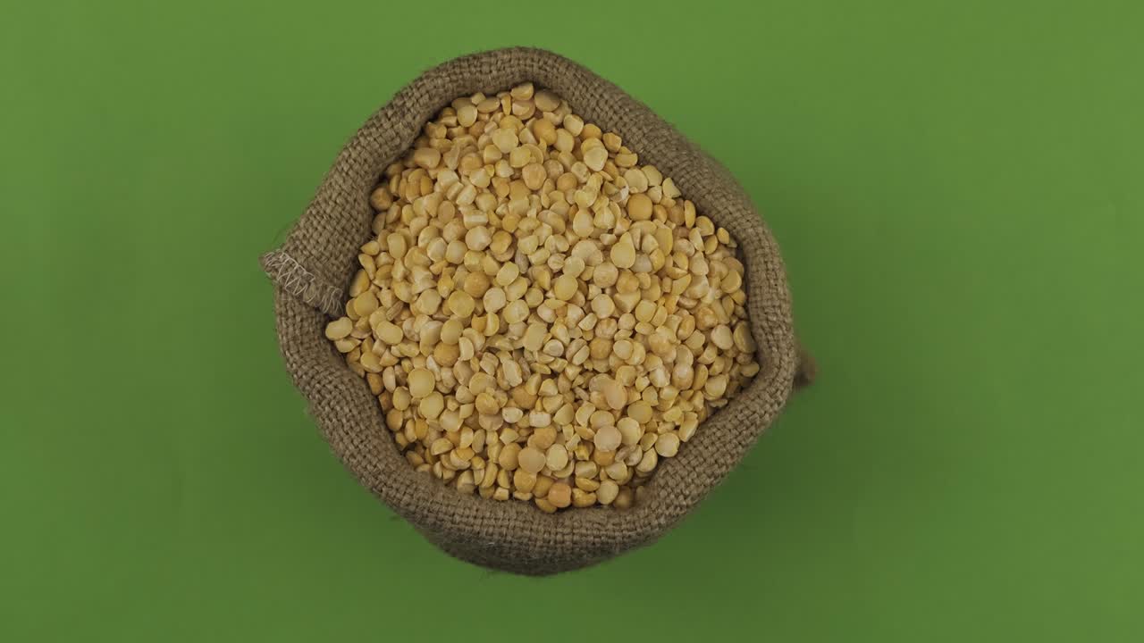Rotation of a full sack of peas grain. Top view. Isolated