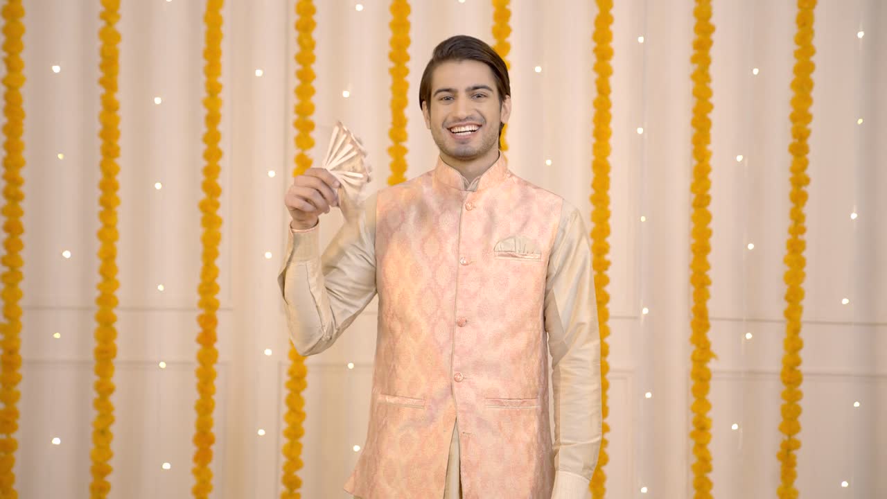 Uomo indiano che si diverte con i soldi a Diwali