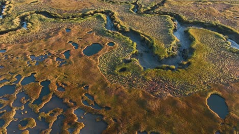aerial view over the rugged landscape of the great salt marsh at cape cod at sunrise.