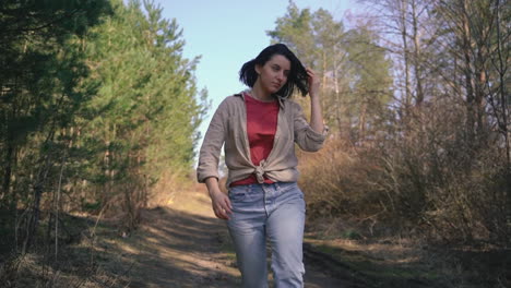 a young beautiful brunette girl runs through a pine forest