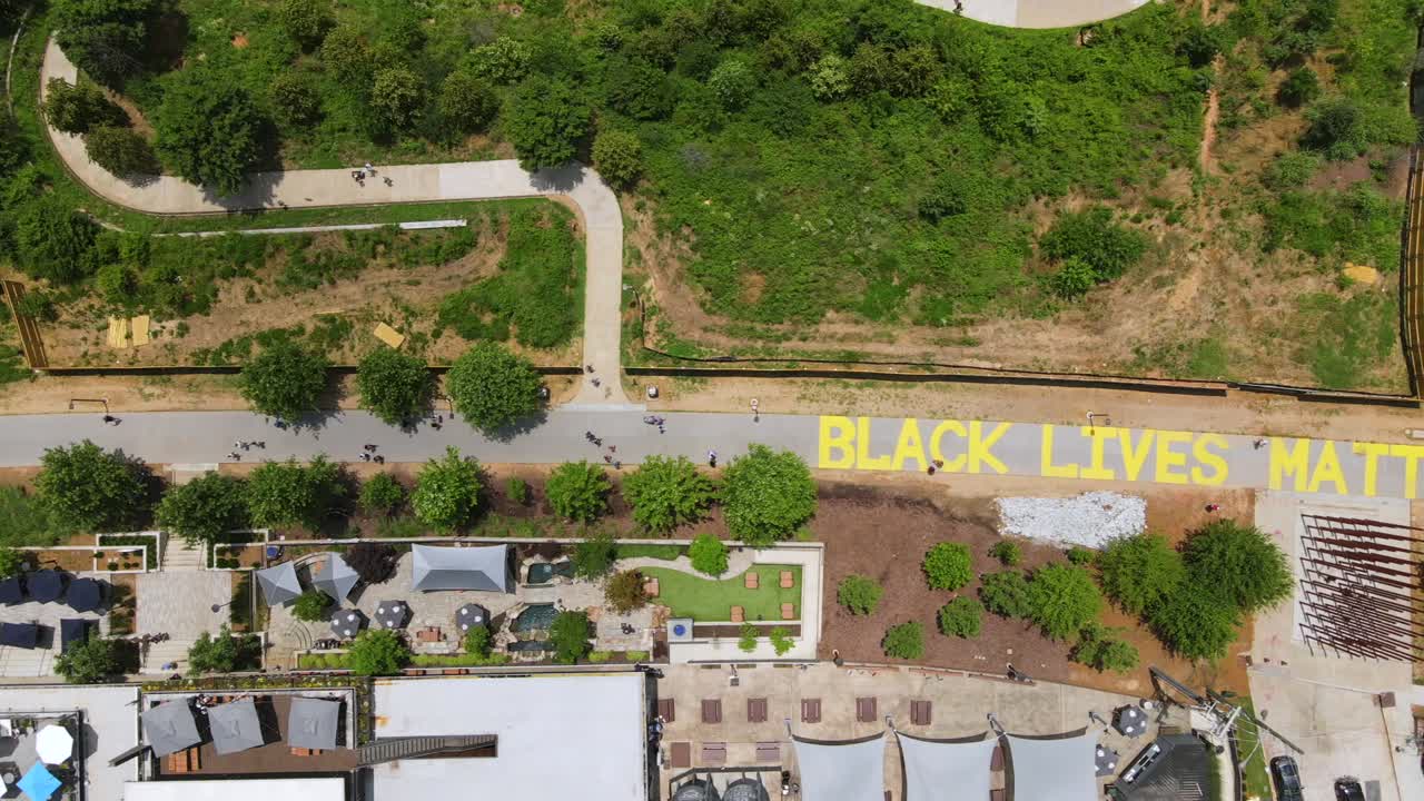 조지아의 애틀랜타 벨트라인에 있는 흑인 생명 문제 벽화를 따라 걷는 사람들의 훌륭한 항공 사진