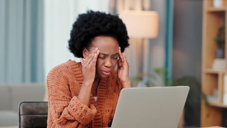 mujer que experimenta dolor de cabeza mientras trabaja en una computadora portátil