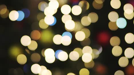 christmas bokeh lights decorate a christmas tree in a large modern shopping center. multicolored bokeh lights of christmas garland. blurred bright christmas lights in the mall. glitter