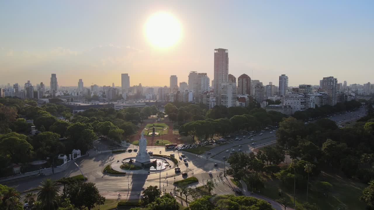 monumento a las avenidas españolas y concurridas rodeadas de bosques de palermo y edificios al fondo al atardecer con sol brillante, buenos aires, argentina